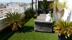 azotea con cesped artificial, sofas y sillones jardin